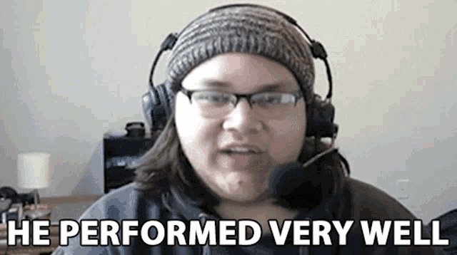 a man wearing headphones and glasses is talking into a microphone .