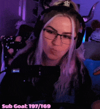 a woman wearing horns and headphones is making a funny face while playing a video game .