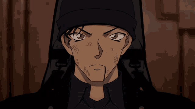 a close up of a man wearing a black hat and a black shirt