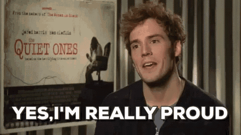 a man is standing in front of a movie poster and saying `` yes , i 'm really proud ''