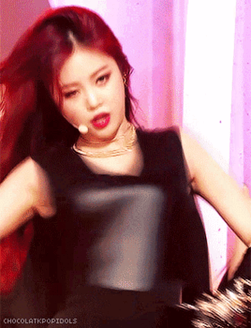 a woman with red hair is wearing a black top