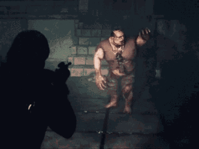 a man is holding a gun in front of a zombie in a dark room