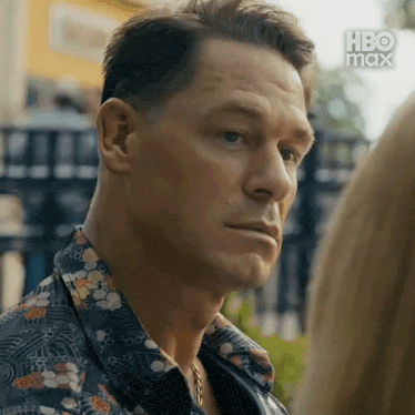 a close up of a man 's face in a floral shirt .