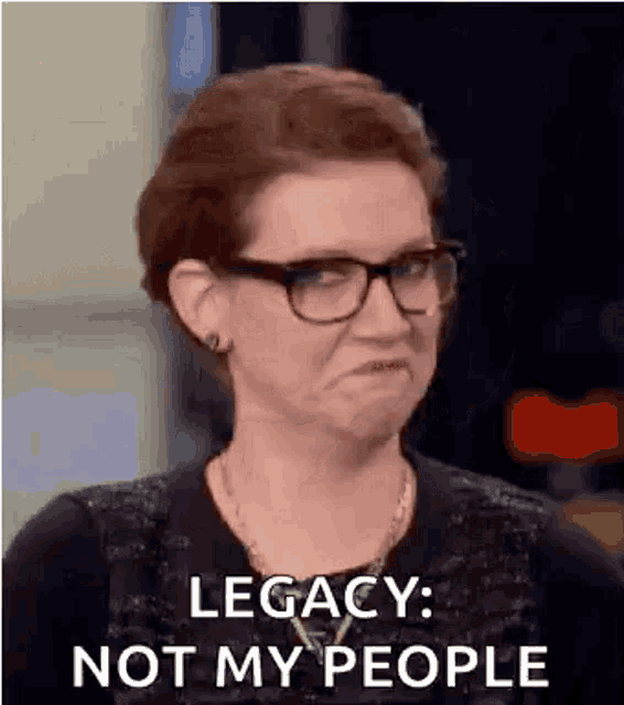 a woman wearing glasses and a black shirt is making a funny face and saying `` legacy : not my people '' .