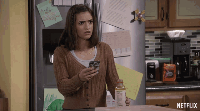 a woman standing in front of a refrigerator with a netflix logo on the bottom right