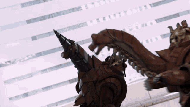 a robot with a drill in its mouth is standing in front of a white building