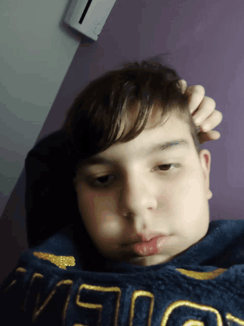 a young boy wearing a blue shirt with the word vision on the front