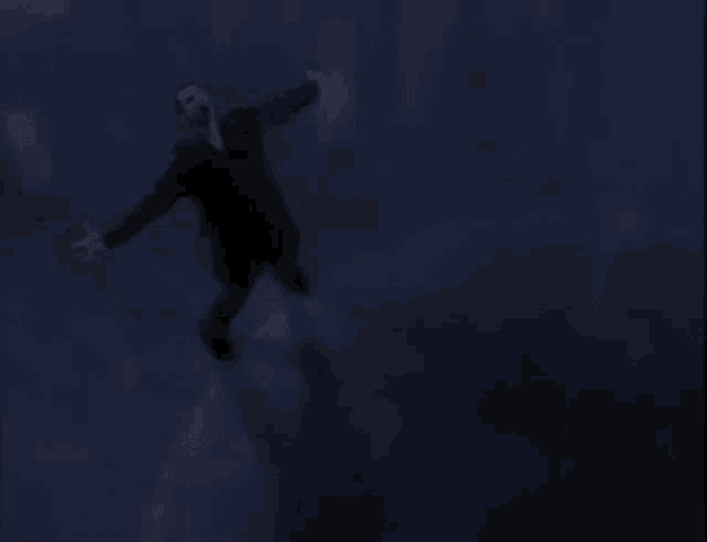 a man is flying through the air in a dark room