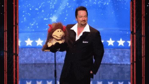 a man in a suit is holding a stuffed animal in front of a blue background with stars
