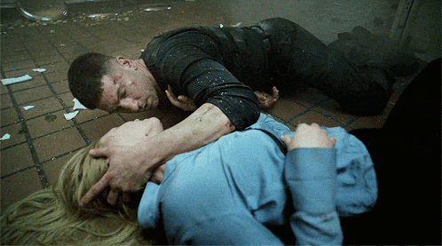 a man and a woman are laying on the floor and the man is holding the woman 's neck