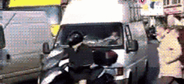 a person riding a motorcycle next to a van