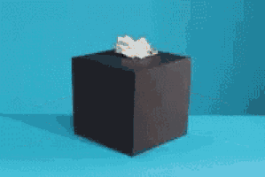 a hand is sticking out of a black box and giving the middle finger .