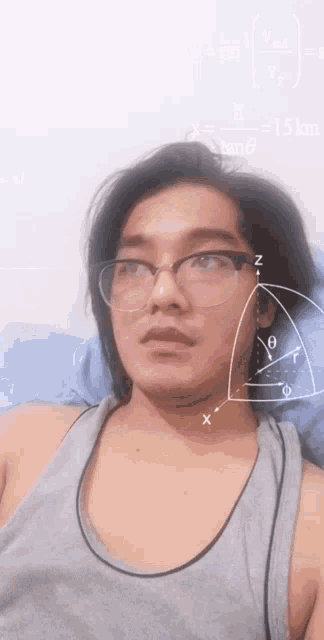 a man wearing glasses is laying on a bed