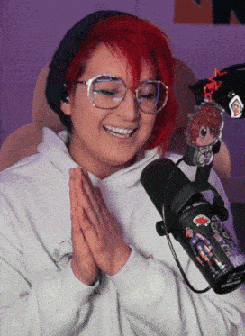 a girl with red hair is smiling in front of a microphone with a sticker on it that says ' jojo ' on it