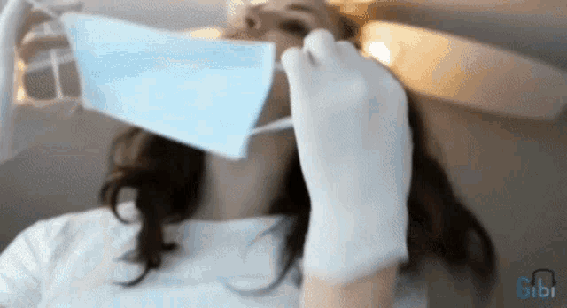 a woman wearing gloves and a mask with the word gibi in the background