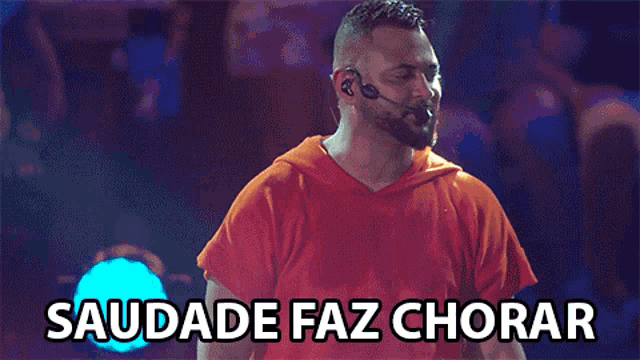 a man wearing a red shirt with the words saudade faz chorar written above him