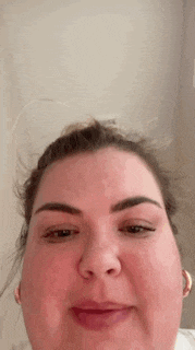 a close up of a woman 's face with the word this visible in the background