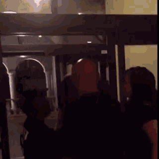 a man standing in front of a door with a sign on it that says ' tech '