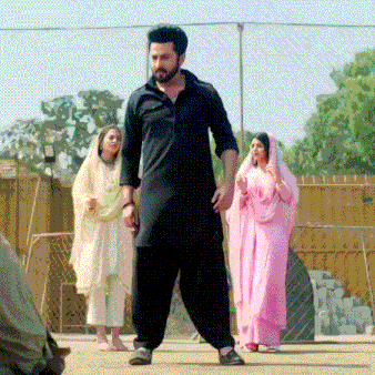 a man in a black kurta stands in front of two women in pink clothes