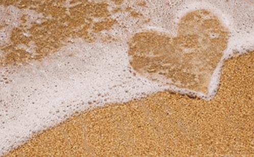 a heart drawn in the sand on a beach