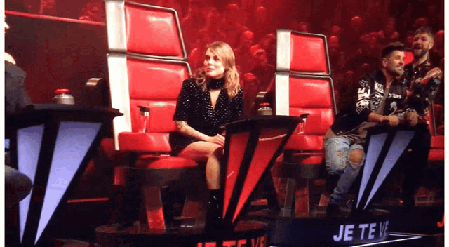 a woman sits in a chair in front of a sign that says " je te ve "