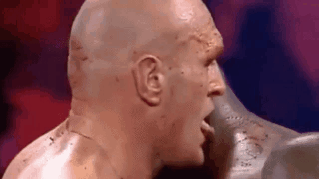 a close up of a boxer 's face with blood on it during a boxing match .