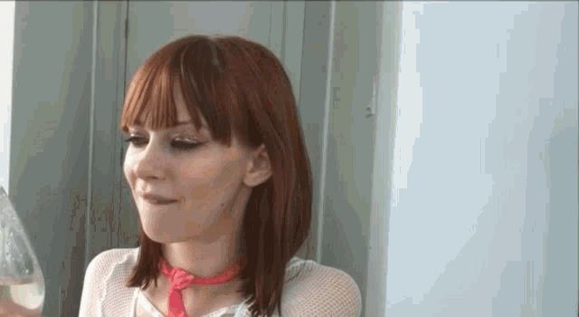 a woman with red hair and a pink scarf around her neck
