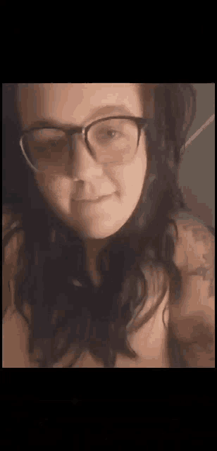 a close up of a woman wearing glasses and a tattoo .