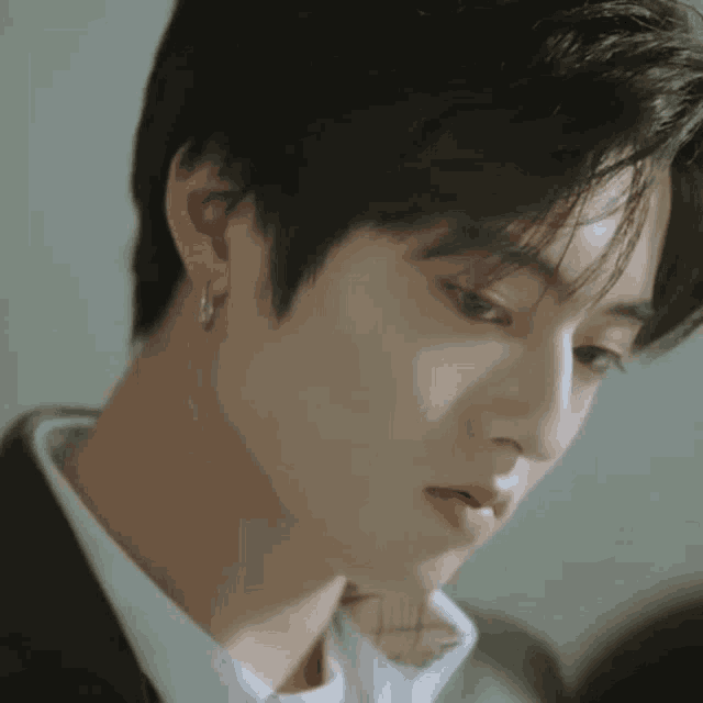 a close up of a man 's face with a white shirt and a black suit