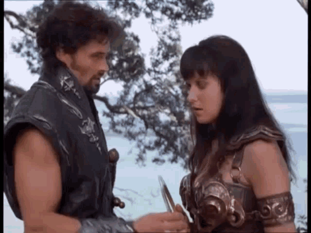 a man and a woman are standing next to each other on a beach .