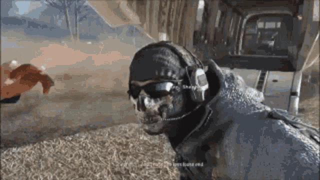 a man wearing a helmet and sunglasses is standing in a field