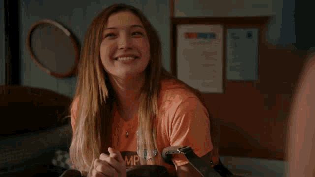 a woman wearing an orange shirt that says amp on it