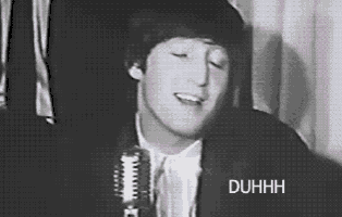 a black and white photo of a man singing into a microphone with the word duhhh above him .