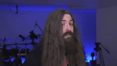 a man with long hair and a beard has the word sex written on his face