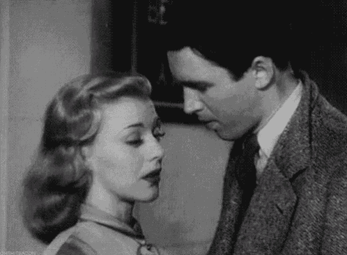 a man and a woman are looking at each other in a black and white photo .