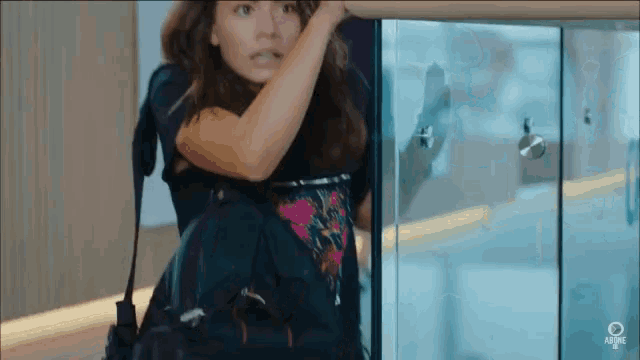 a woman in a black shirt is standing in front of a glass door that says adtime on the bottom