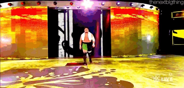 a man is standing on a stage in front of a large screen that says the nextbigthing