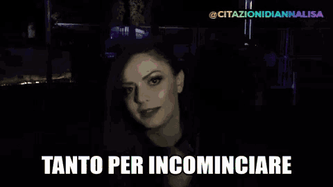 a woman in a dark room with the words tanto per incominciare below her