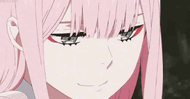 a close up of a pink haired anime girl with blue eyes making a funny face .