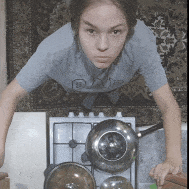 a girl wearing a shirt that says " day " is doing push ups on a stove