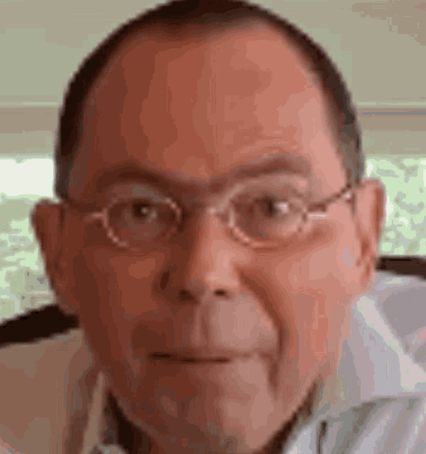 a close up of a man wearing glasses and a white shirt