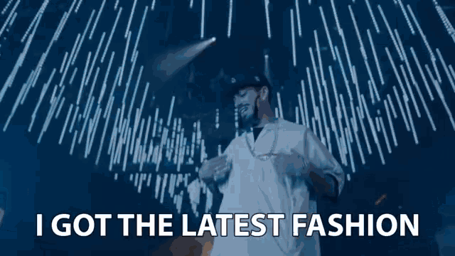 a man in a white shirt stands in front of a blue background with the words i got the latest fashion