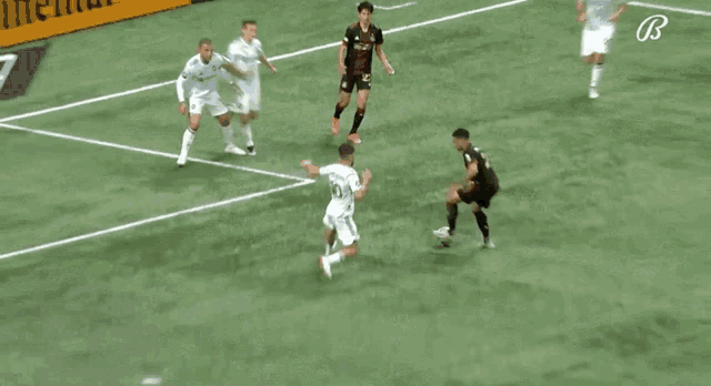 a group of soccer players are playing on a field and one player has the number 8 on his jersey