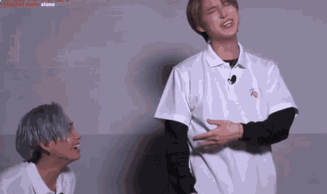 two young men are standing next to each other and one of them is laughing