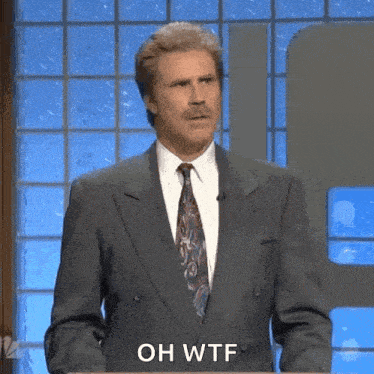 a man in a suit and tie is standing at a podium and saying oh wtf