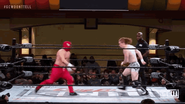 two wrestlers are in a ring with the letters gcw on the ring