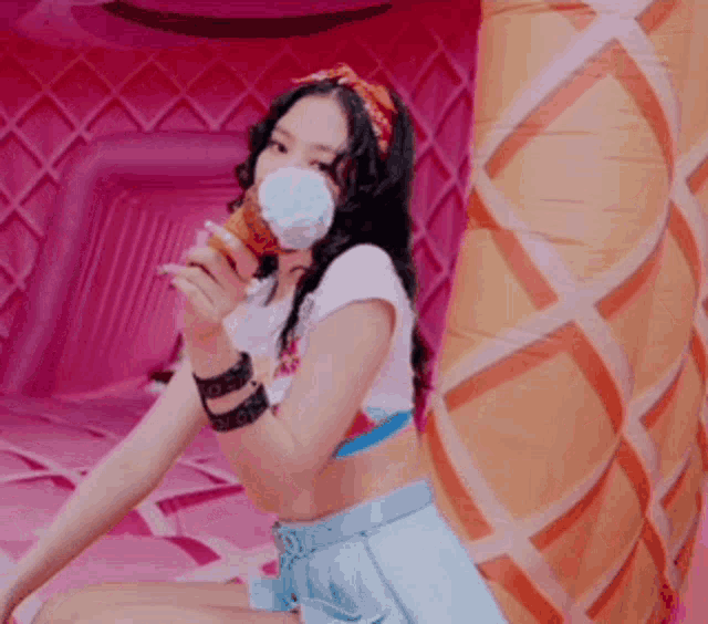 a woman is holding an ice cream cone in front of an inflatable ice cream cone ..