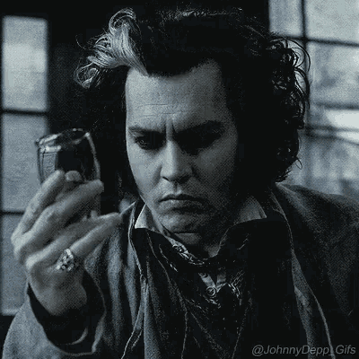 a man with a ring on his finger is looking at a cell phone