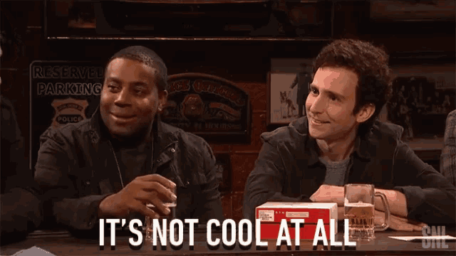 a group of men sitting at a table with the words it 's not cool at all