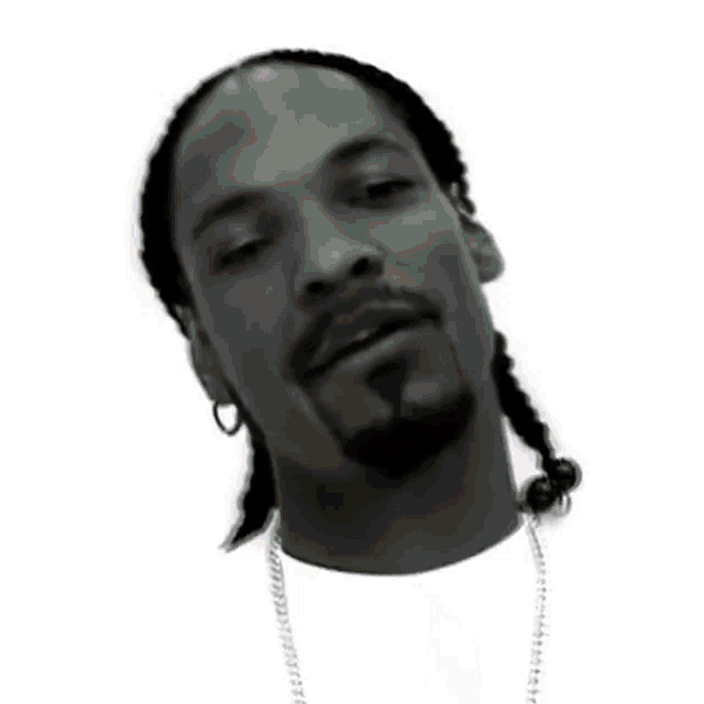 a black and white photo of a man wearing a hat and a necklace holding something .